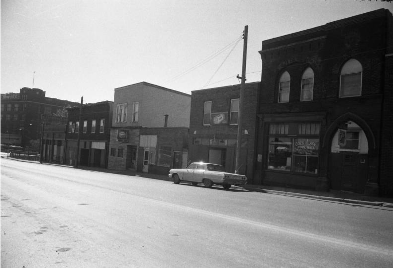 Building facades on a street with a vintage car parked out front Building facades on a street with a vintage car parked out front